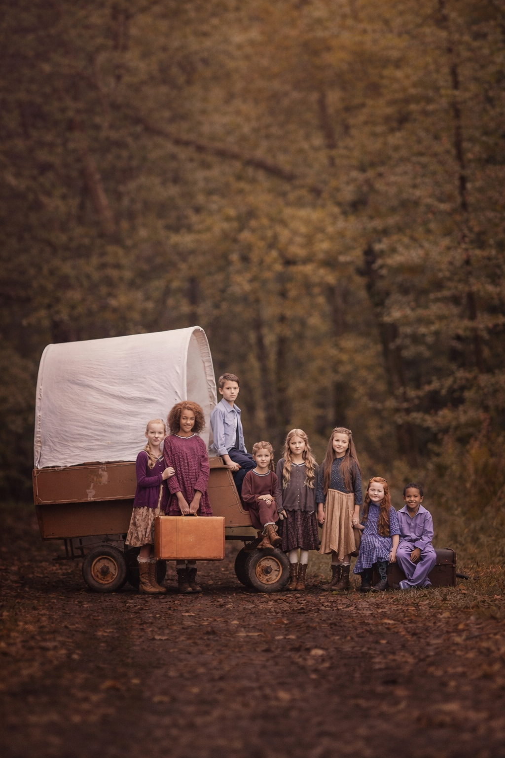 Children sitting in a rustic wagon during a farm portrait session in New Jersey, surrounded by open fields and natural scenery