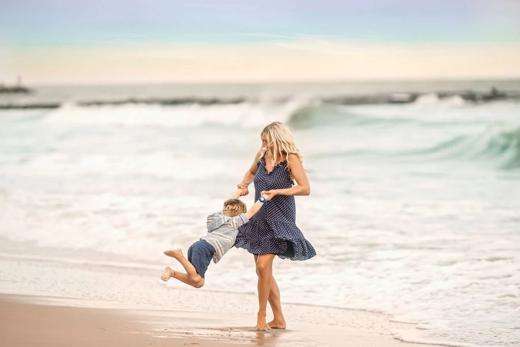 Mother lifting her son in the air during a Jersey Shore beach family photography session in Atlantic City.