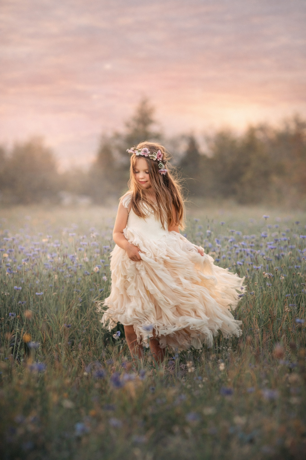 A child in a flowing dress moves through a field of wildflowers, creating a natural and movement-based portrait during late spring in South Jersey.