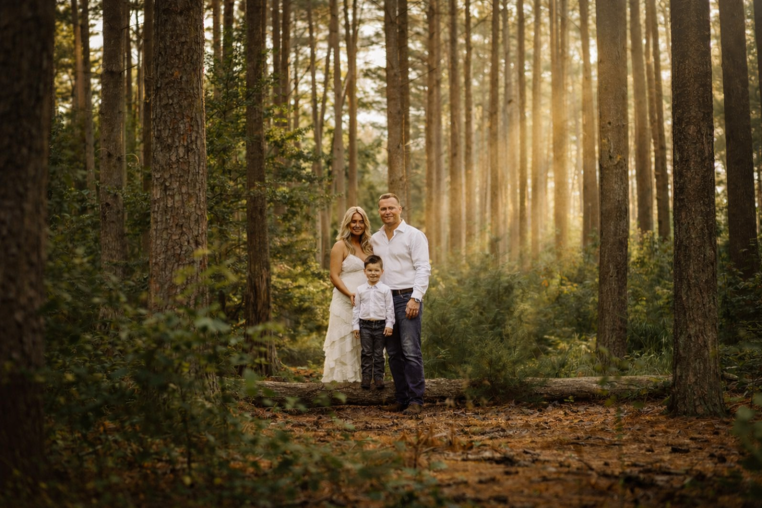 Family standing together in warm forest light during a South Jersey family portrait session