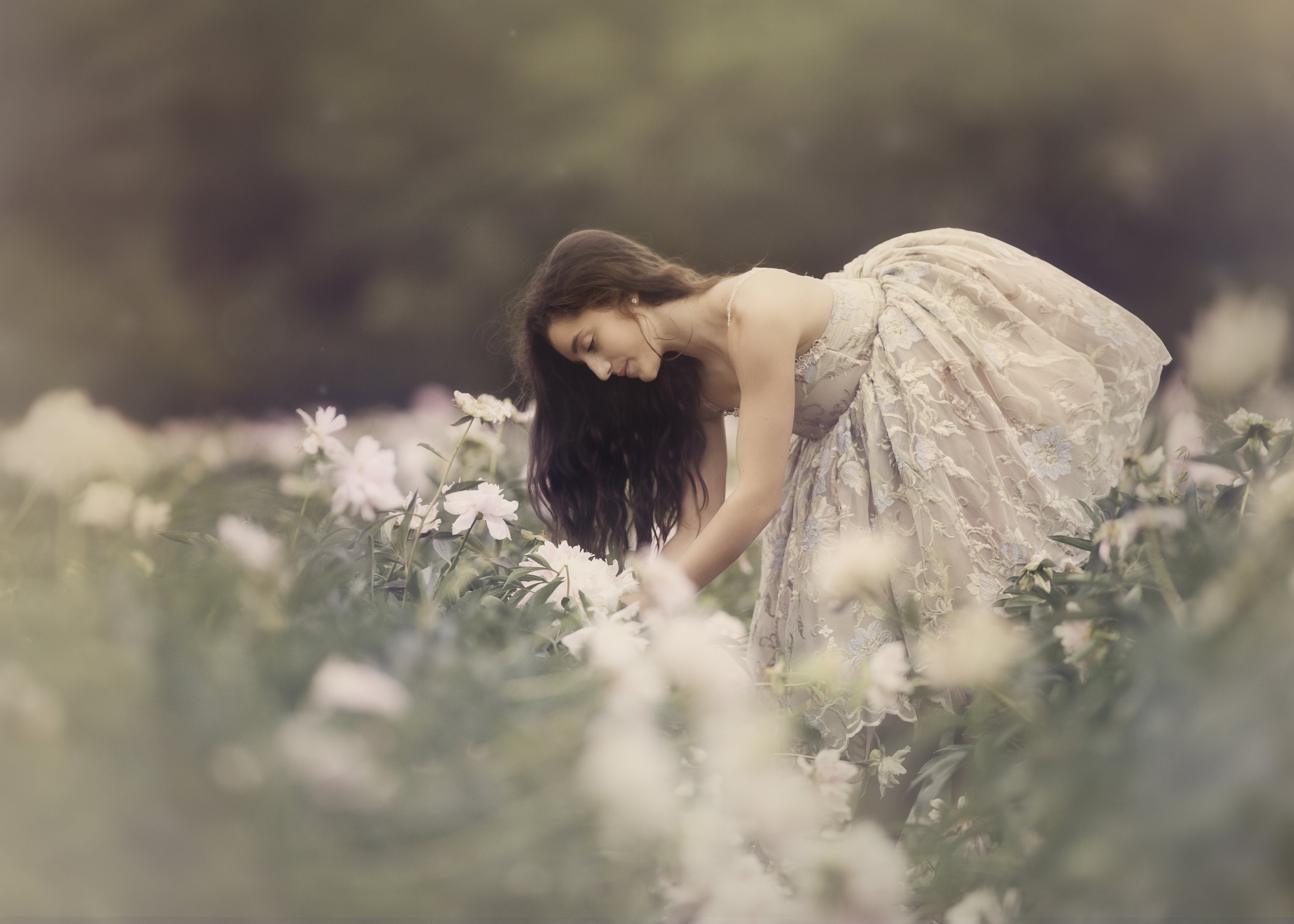 An editorial-style teen fine art portrait photographed in a floral setting, emphasizing natural movement, softness, and a painterly expressive aesthetic. 