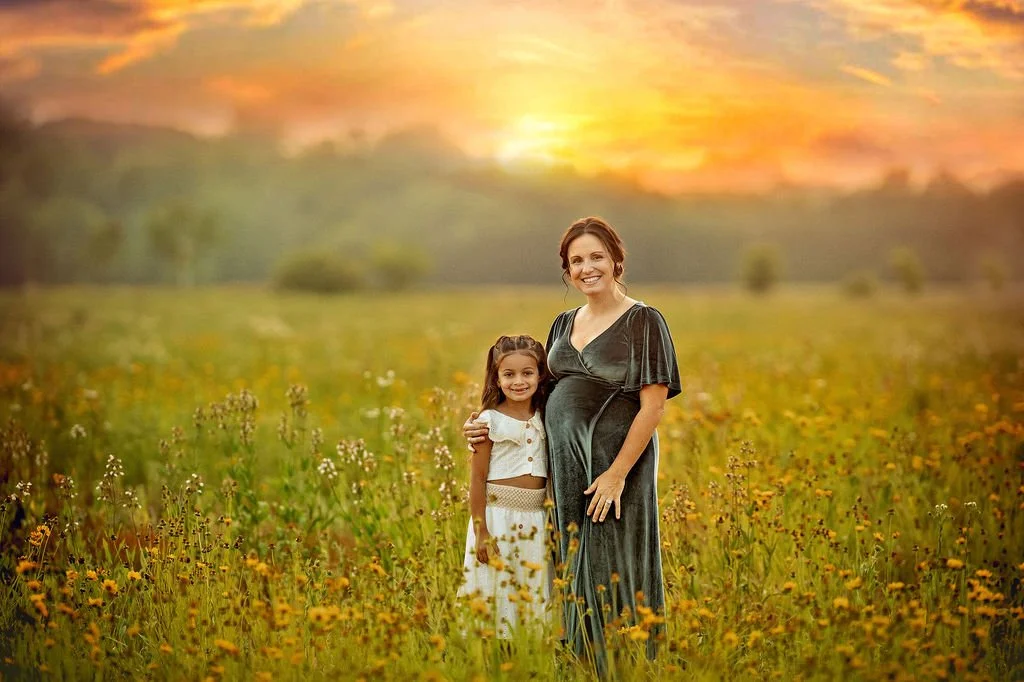Pregnant mother and daughter smiling together during a wildflower maternity photography session in South Jersey.