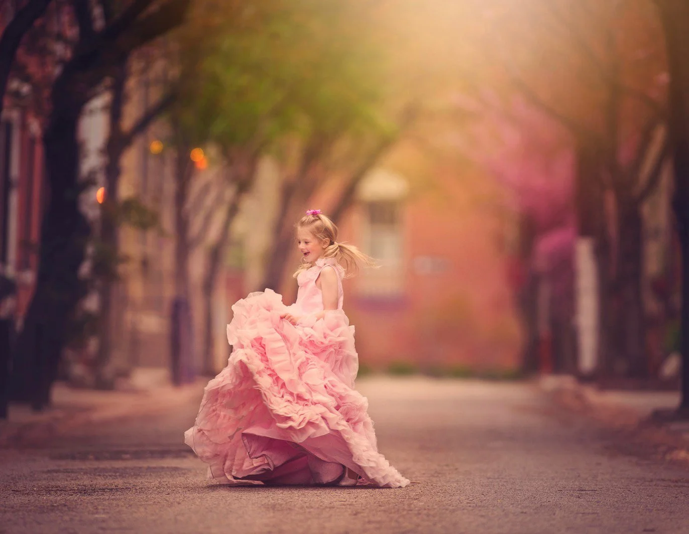 Girl in a pink dress laughing during a child portrait session in Philadelphia.