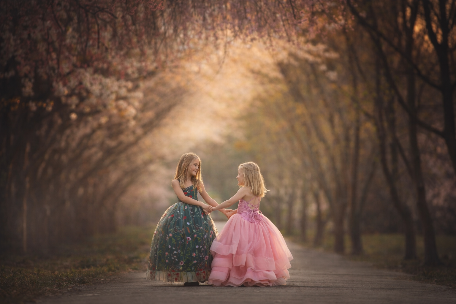 two girls holding hands under cherry blossoms in Philadelphia spring session