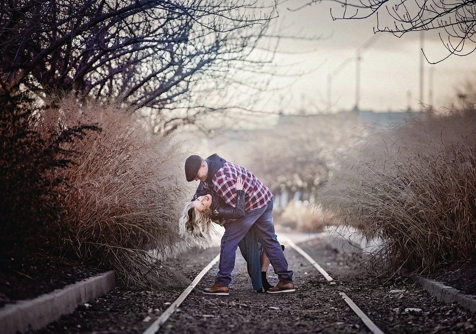 couple laughing and having fun together during a portrait session in Philadelphia with an urban backdrop