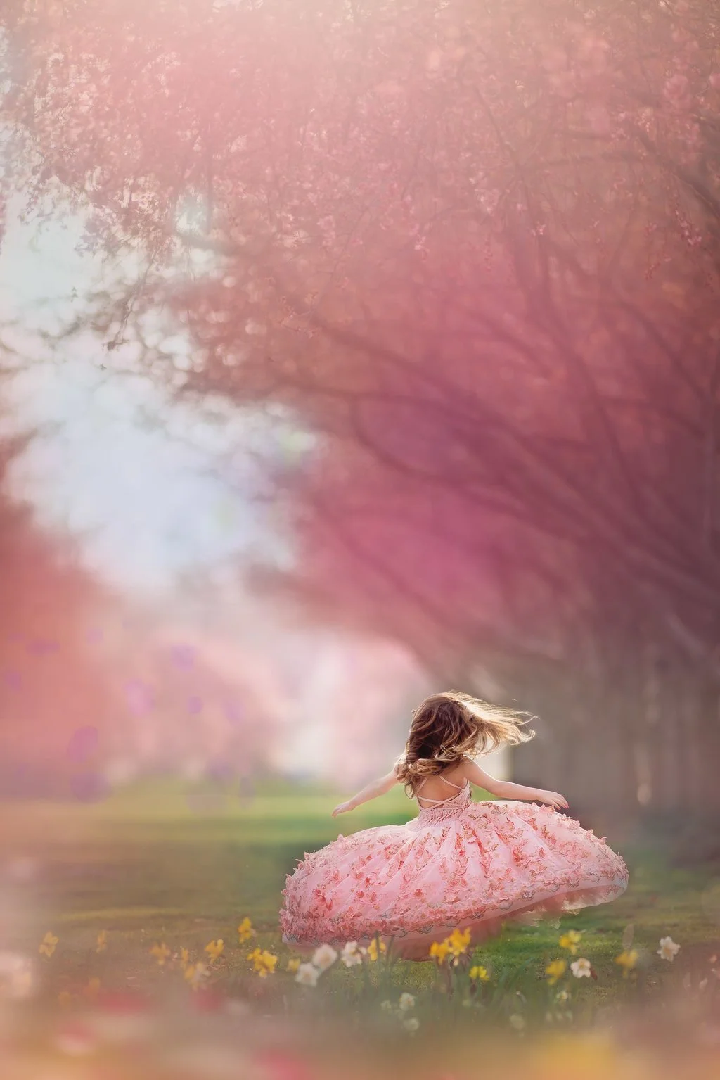 Young girl twirling in a soft pink dress during a fine art children’s portrait session in Philadelphia