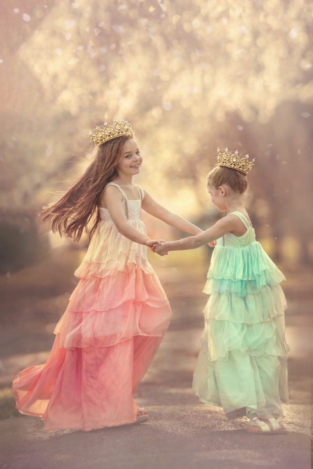Fine art princess portrait of two young girls holding hands in an elegant fairytale setting