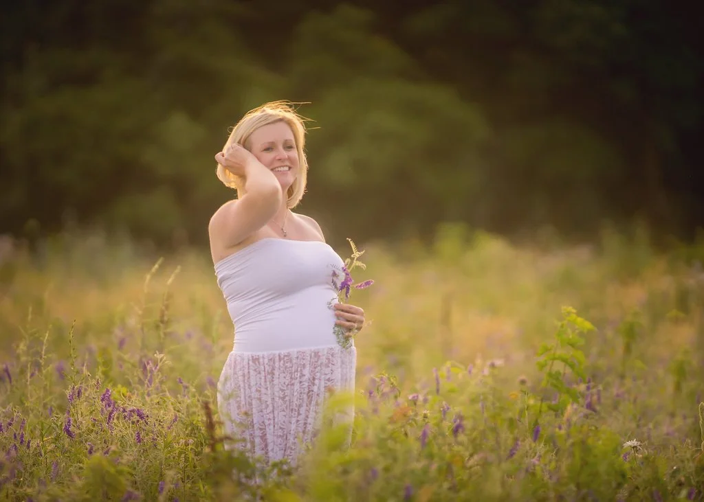 pregnant mother smiling in sunset field during New Jersey maternity session