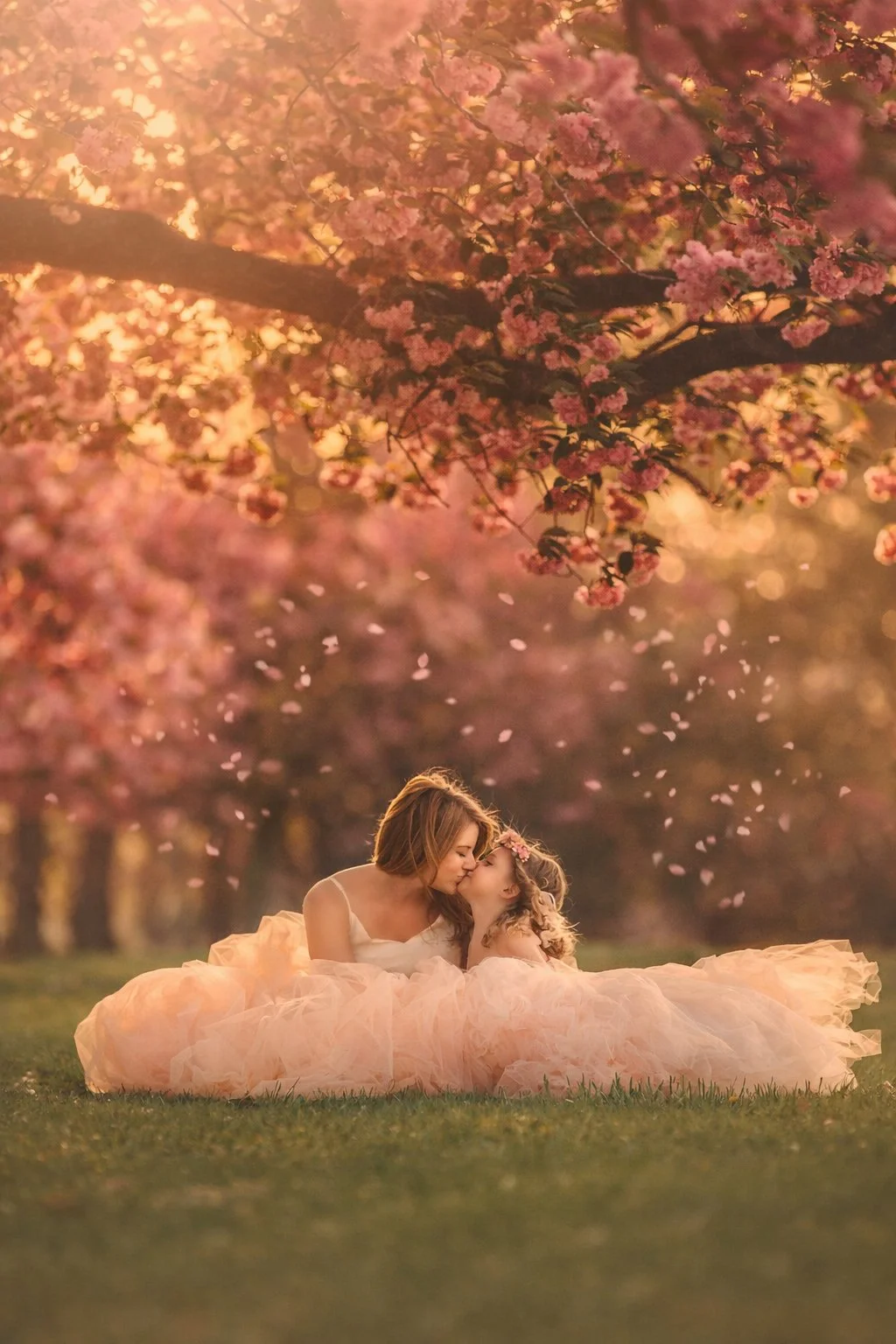 Mother kissing her little daughter during a cherry blossom portrait session in New Jersey.