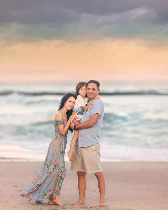 Mom, dad, and son posing calmly during a Cape May family portrait session by the beach