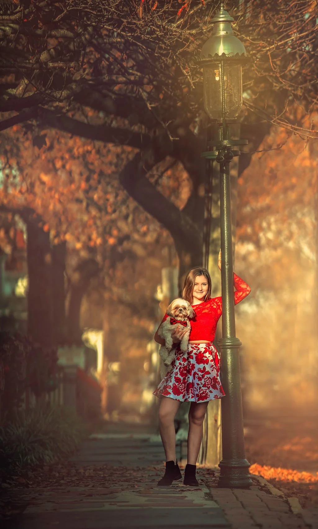 Teen with her dog under a vintage gas lamp during a Cape May family photography session along the Jersey Shore.