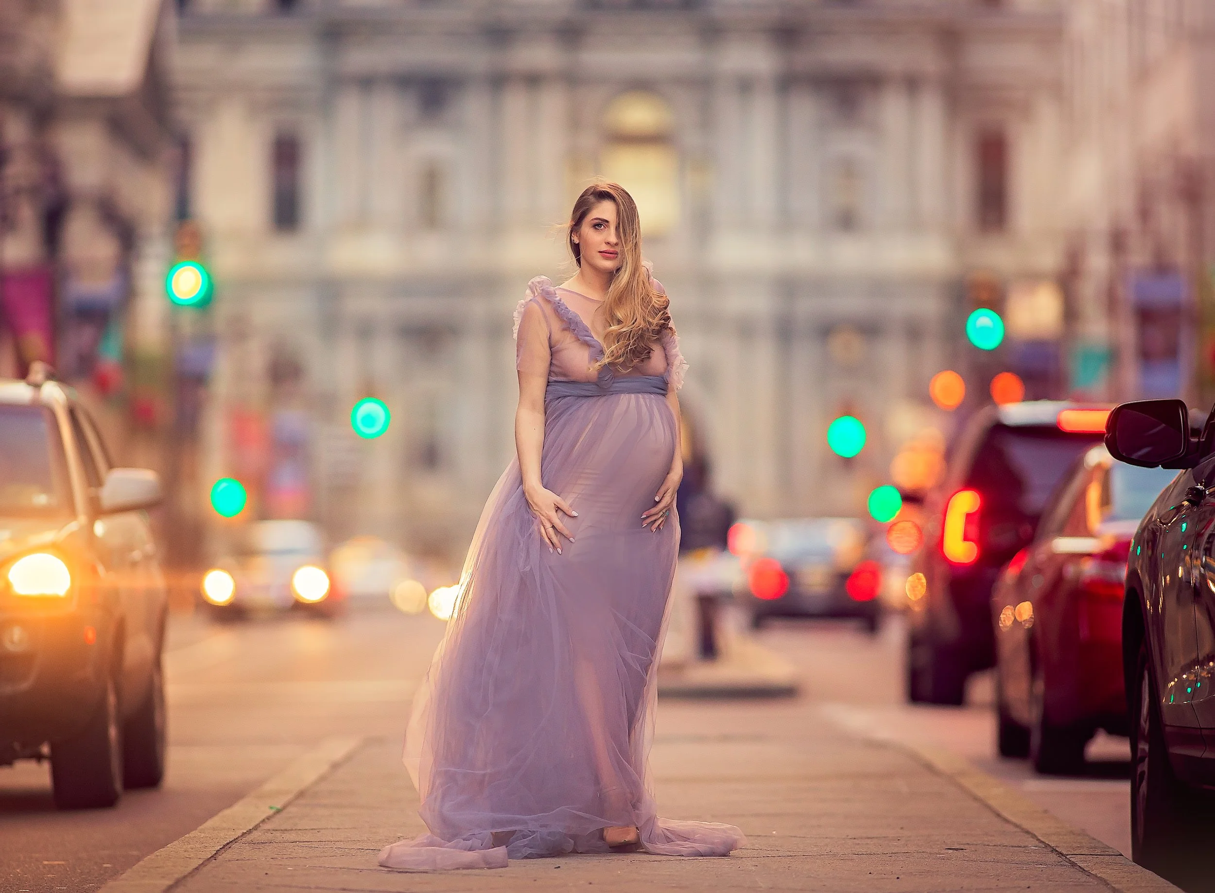 A fine-art maternity portrait photographed in Philadelphia, featuring soft light, flowing fabric, and an elegant, peaceful expression against a classic city backdrop.
