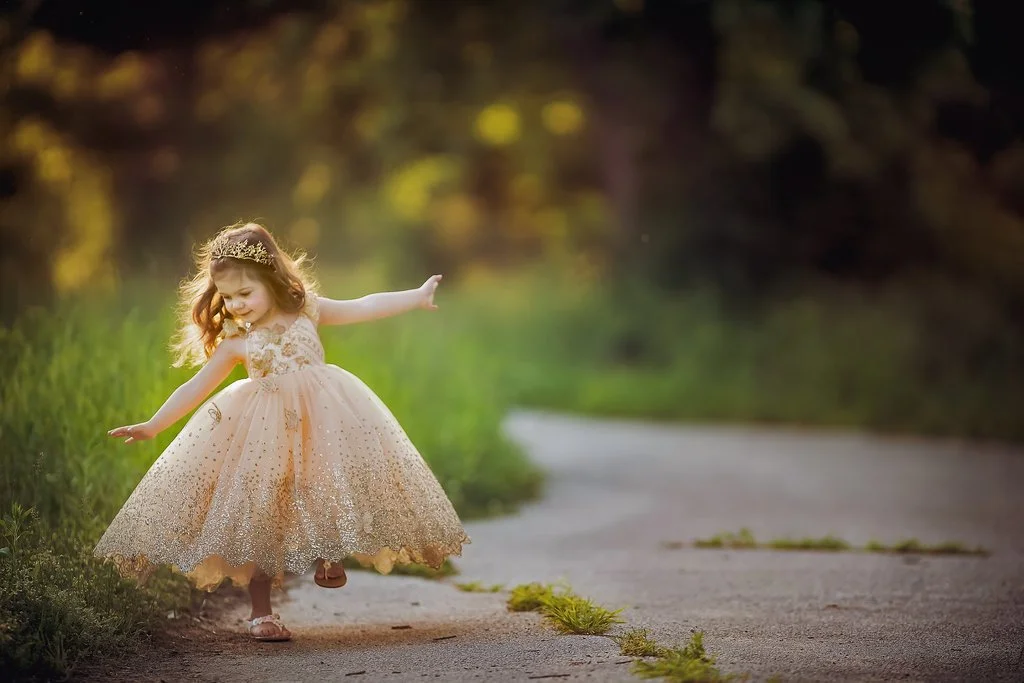 toddler girl twirling in sunlight during outdoor portrait session in Sewell New Jersey