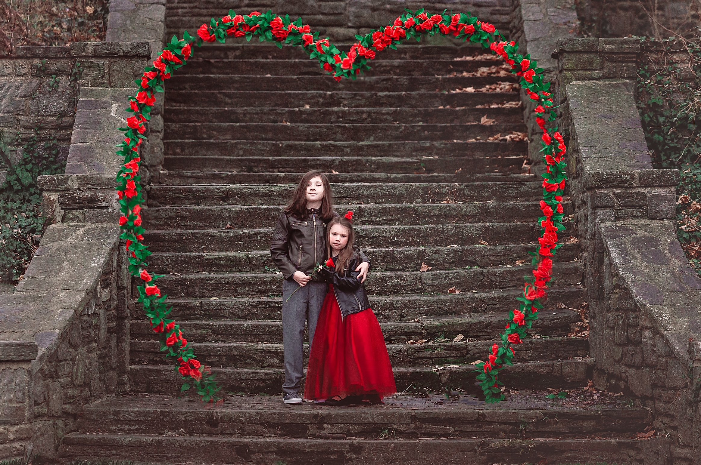 Sister and brother posing together inside a floral heart arch during a Valentine’s portrait session in New Jersey.