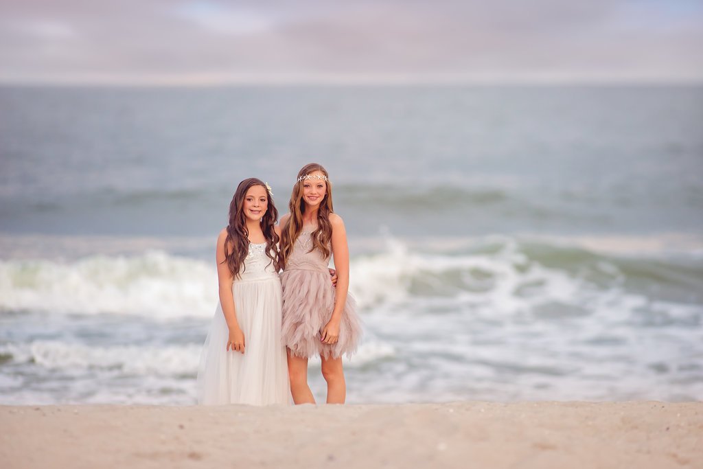 Two sisters posing together near the water during a South Jersey family beach photography session at the Jersey Shore