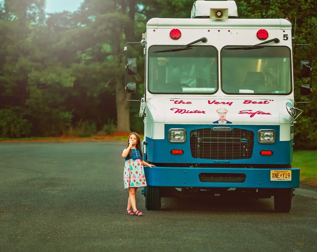 Sister smiling she stands beside the ice cream truck