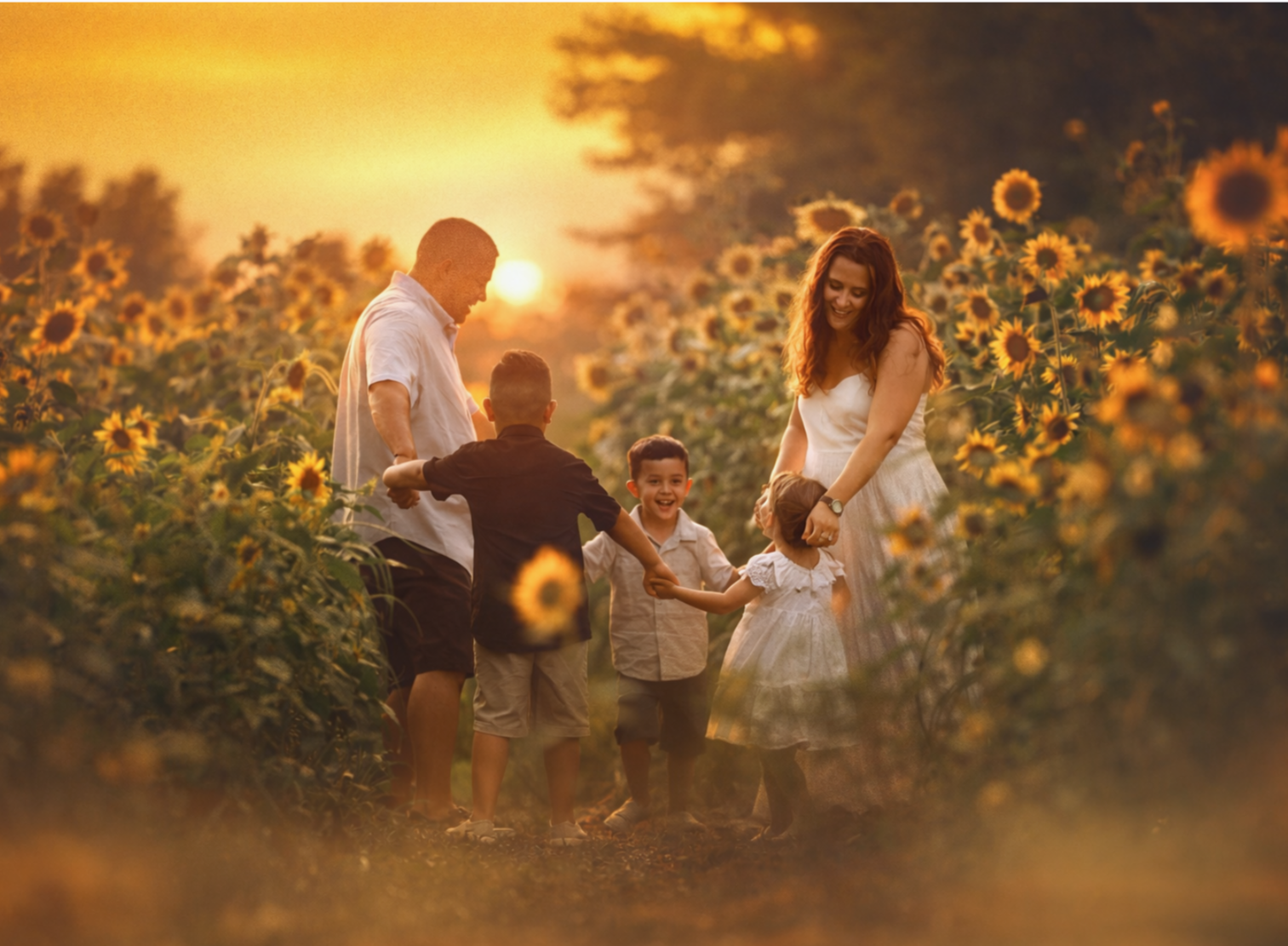 Family walking together through a sunflower field during a summer family photography session in South Jersey.