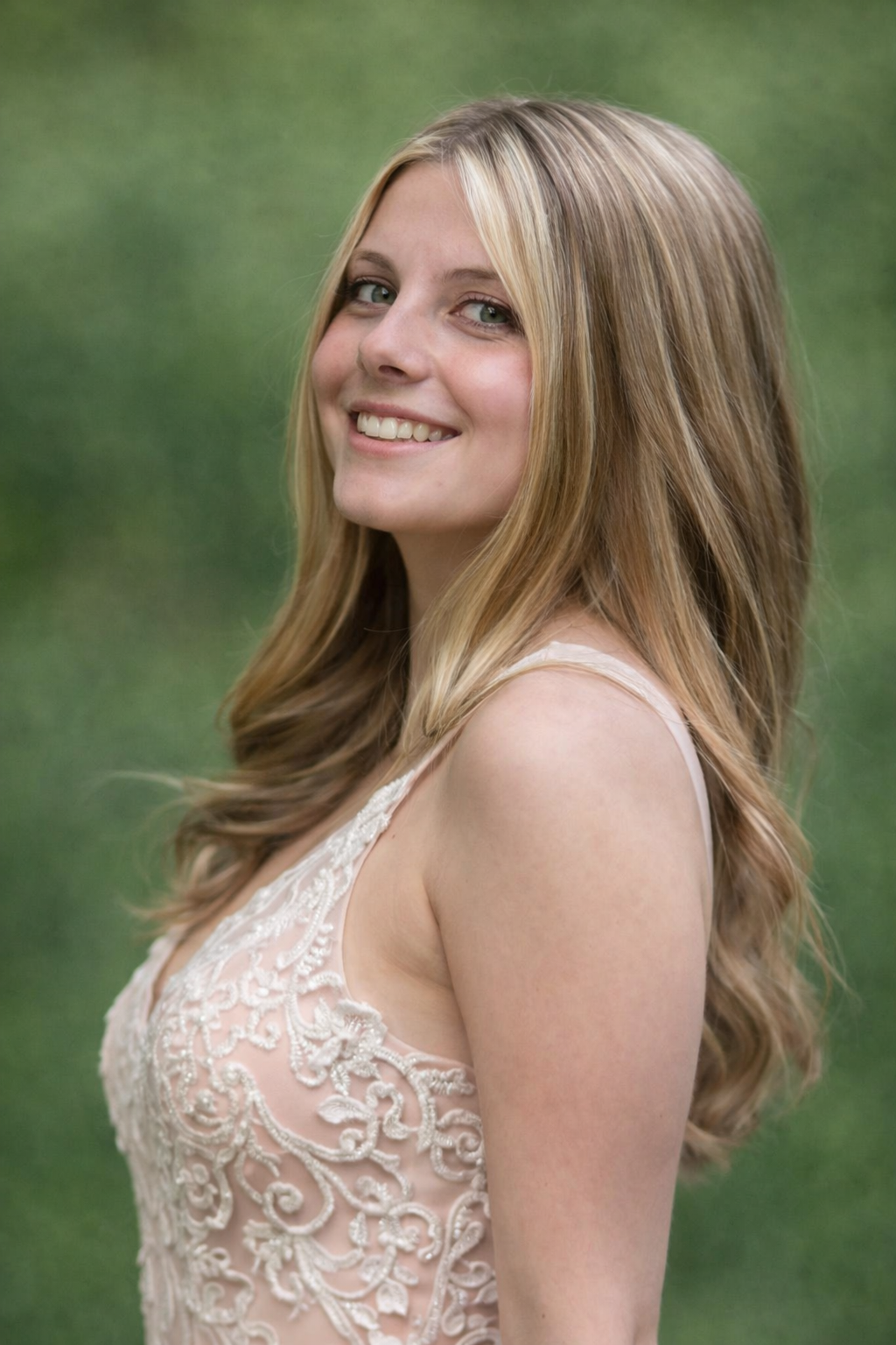 Teen girl smiling during an outdoor portrait session near Philadelphia with soft natural light and greenery background