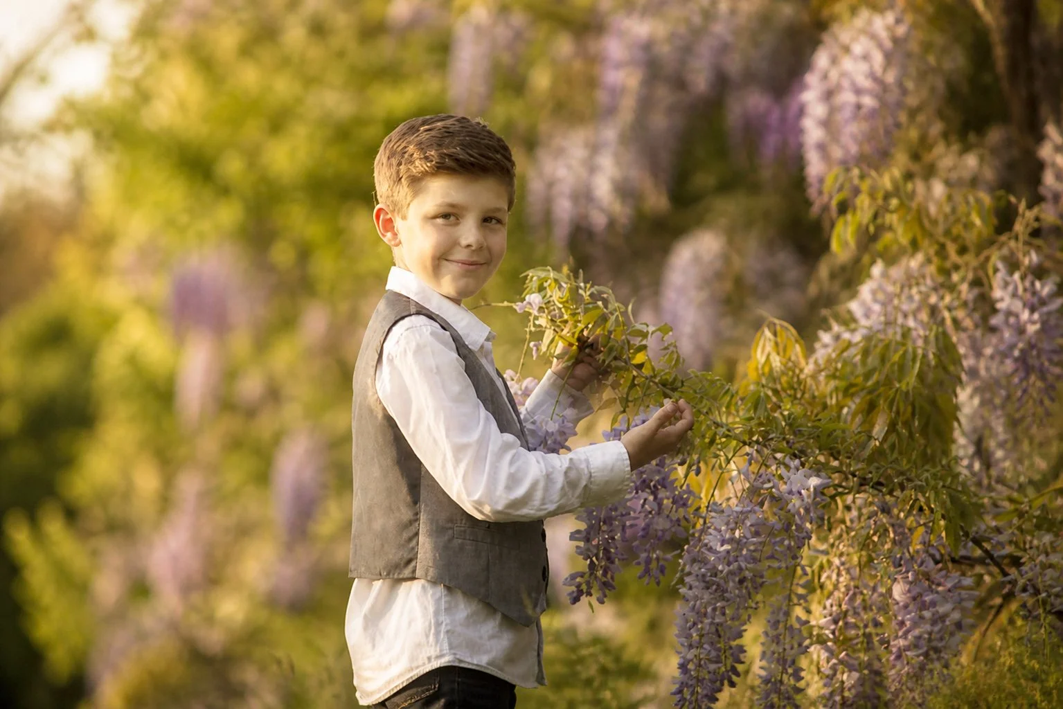 Close-up portrait of a young boy in vintage-inspired clothing during a spring wisteria portrait session in South Jersey