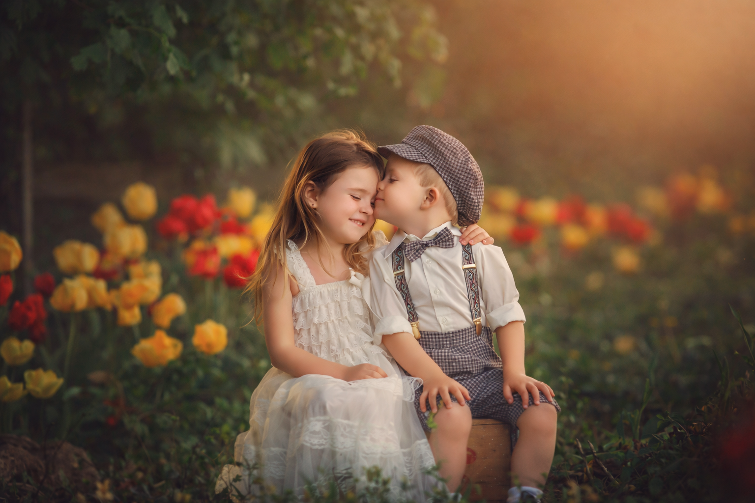 A little boy kisses his sister while standing in a field of tulips at Dalton Farms in South Jersey, creating a heartfelt spring portrait filled with connection, warmth, and seasonal beauty.