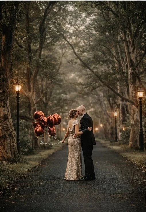 gorgeous editorial engagement session at fonthill castle in doylestown with red balloons along the path and couple kissing
