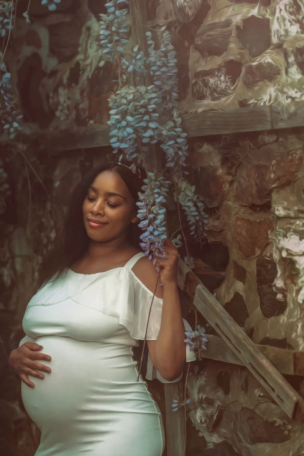 Expectant mother surrounded by wisteria flowers during a maternity session at Ridley Creek State Park