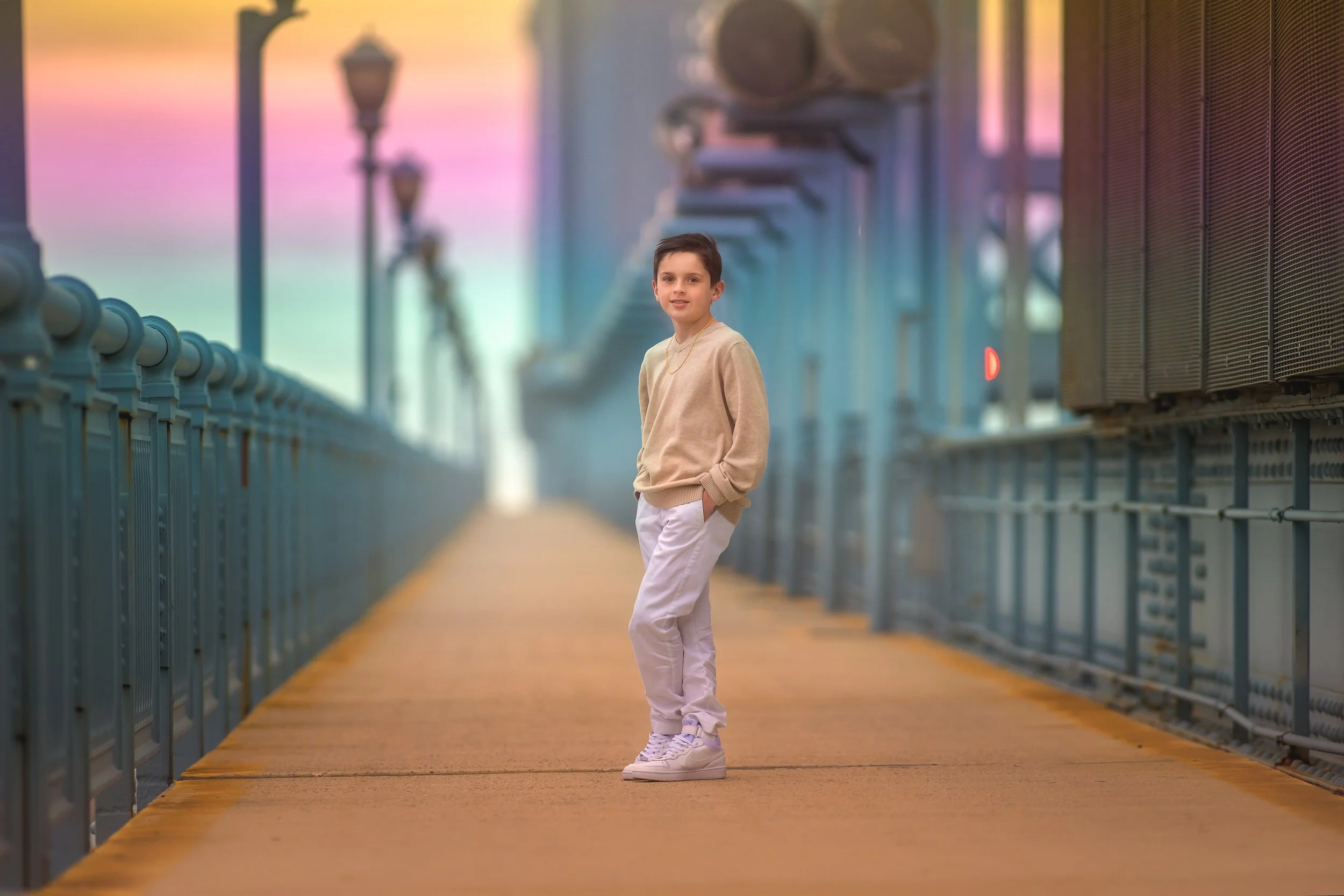 A relaxed portrait of a young boy on a Philadelphia bridge, photographed with gentle direction and natural posture for a timeless, confident feel.