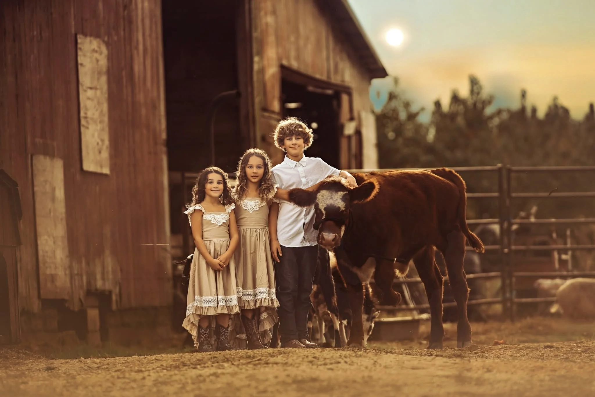 Children posing with a highland cow during an outdoor portrait experience