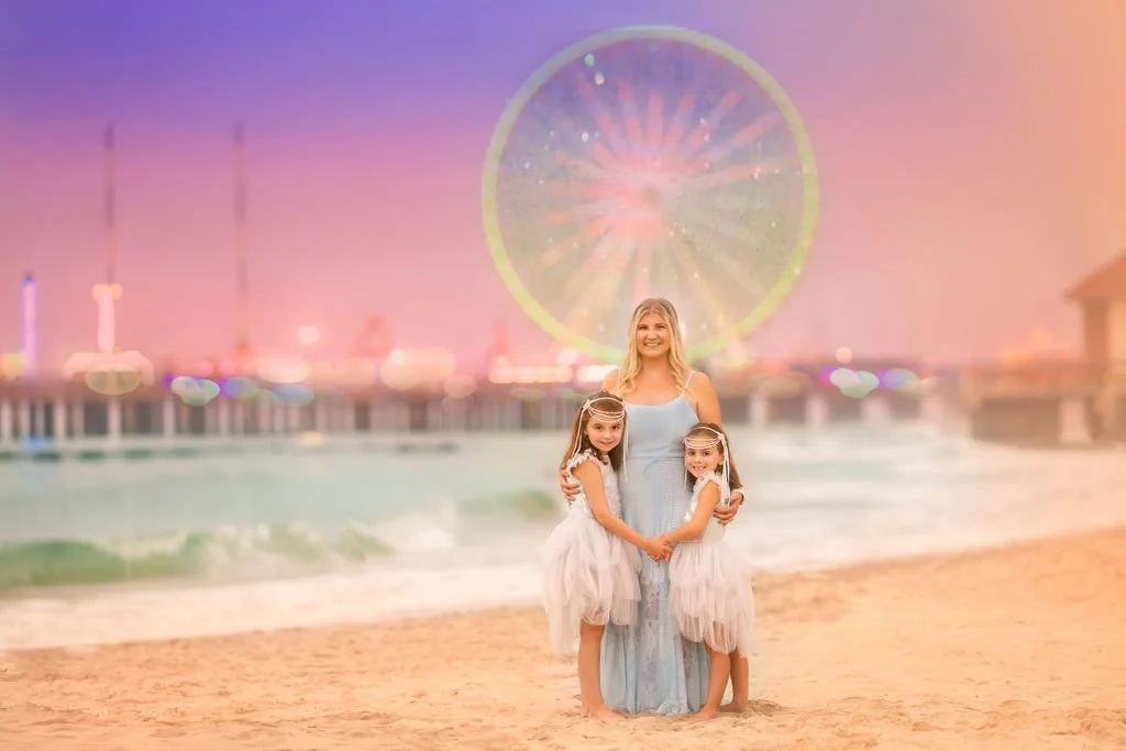 Mother with her two daughters photographed in front of a ferris wheel in Atlantic City during a Jersey Shore family photography session.