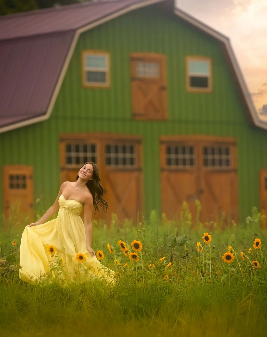 Teen girl in a flowing yellow dress posing in a sunflower field during a South Jersey senior portrait session near a rustic barn.