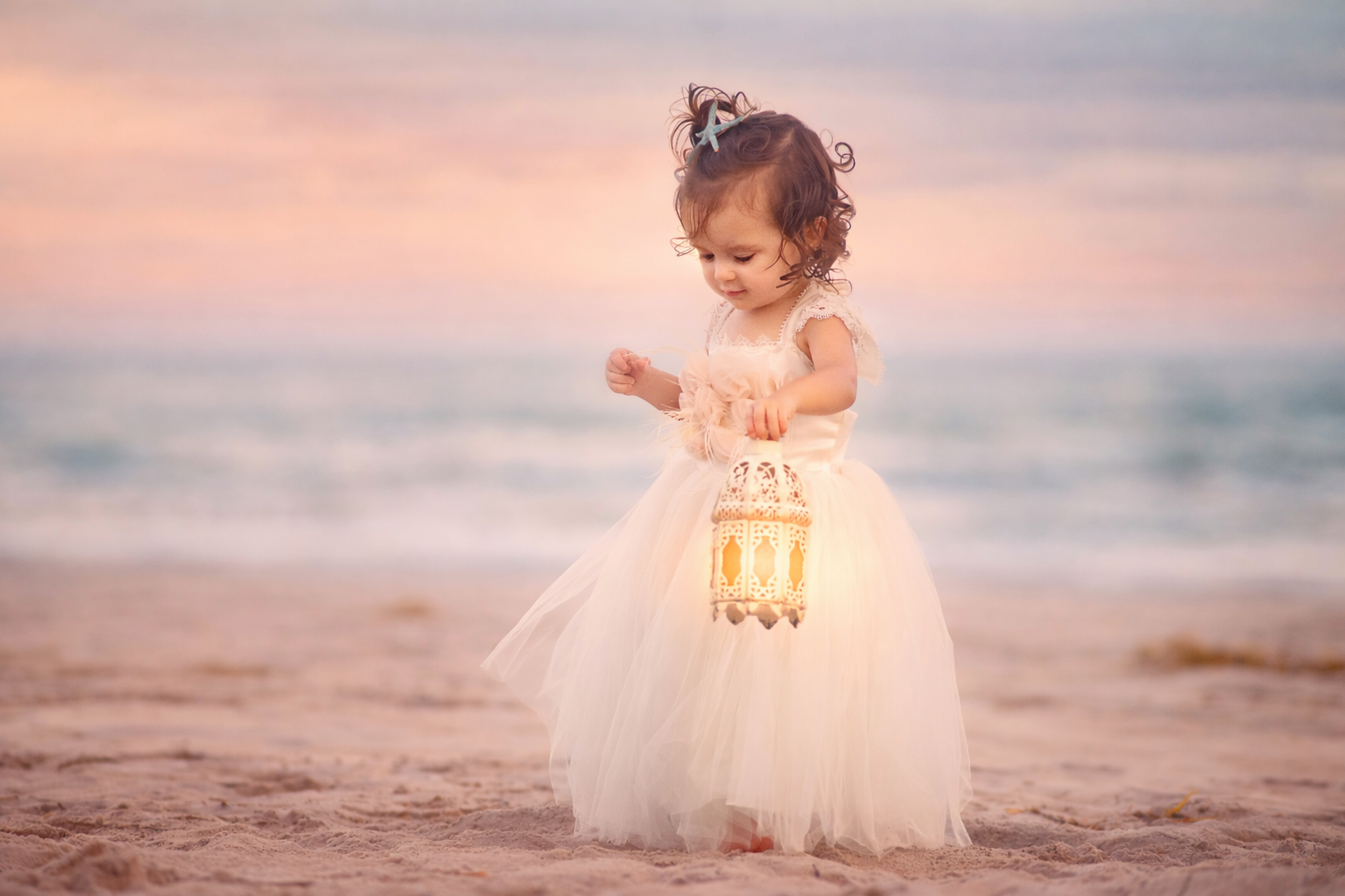 oddler girl in dress holding lantern on the beach during sunset in Ocean City New Jersey