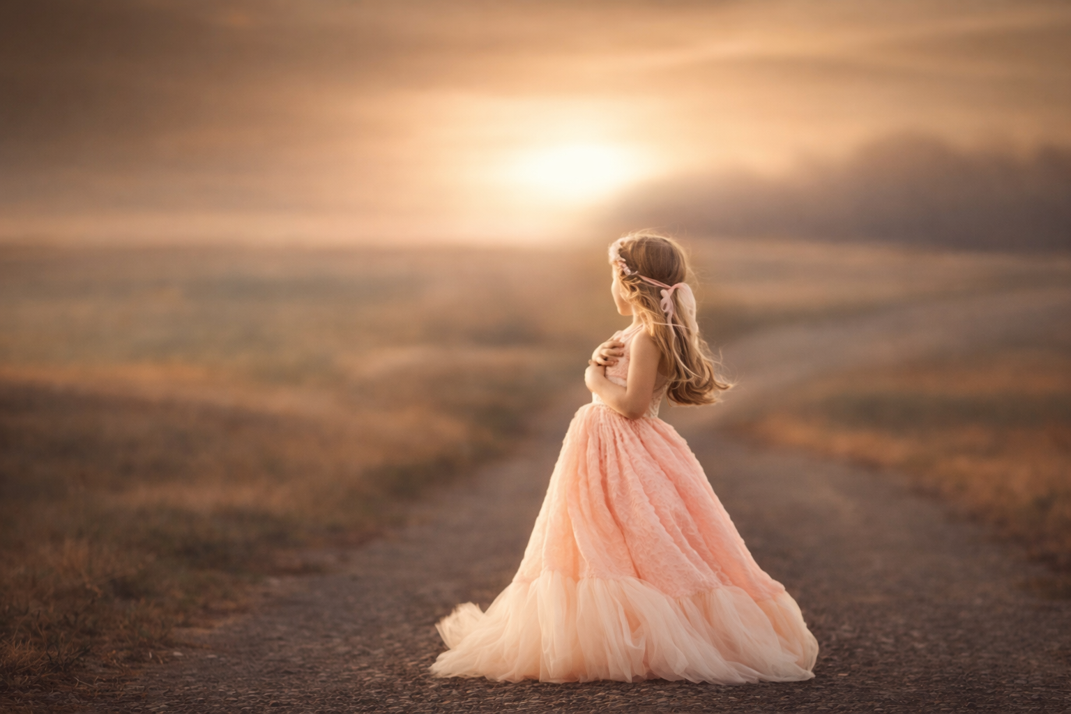 A young girl in a pink dress photographed at sunset in soft natural light for a timeless fine art children’s portrait.