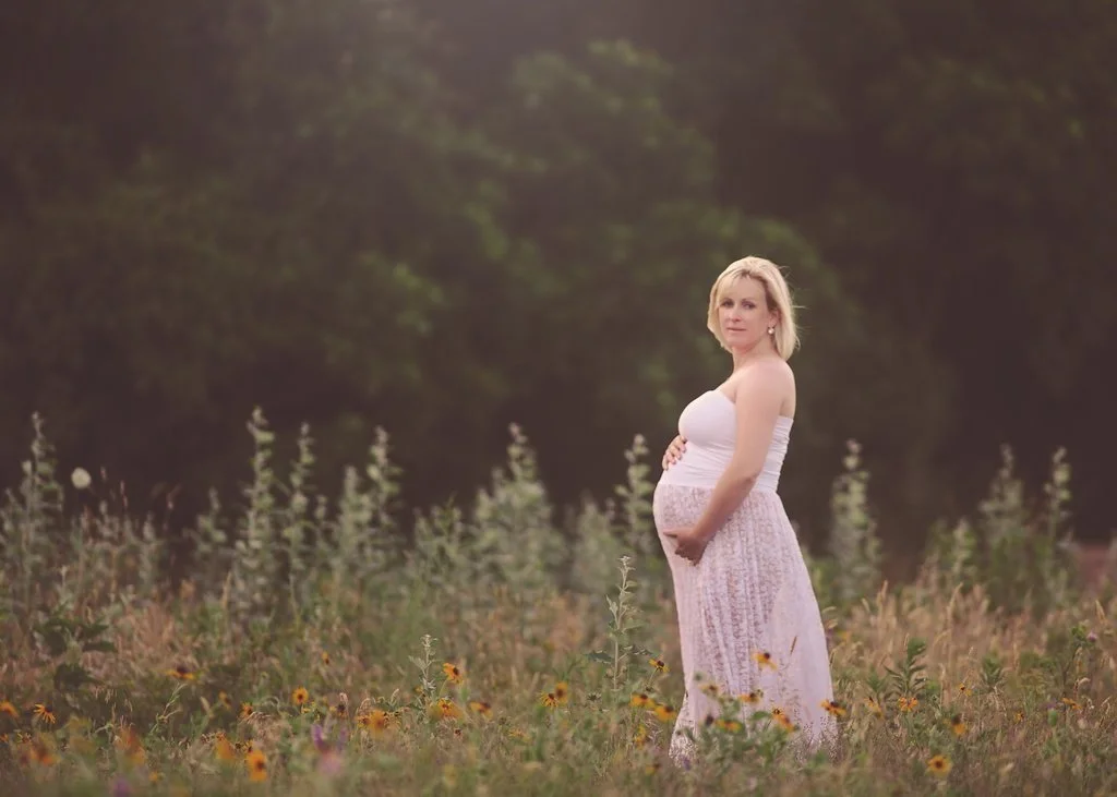 pregnant woman posing in wildflower field during Gloucester County maternity session