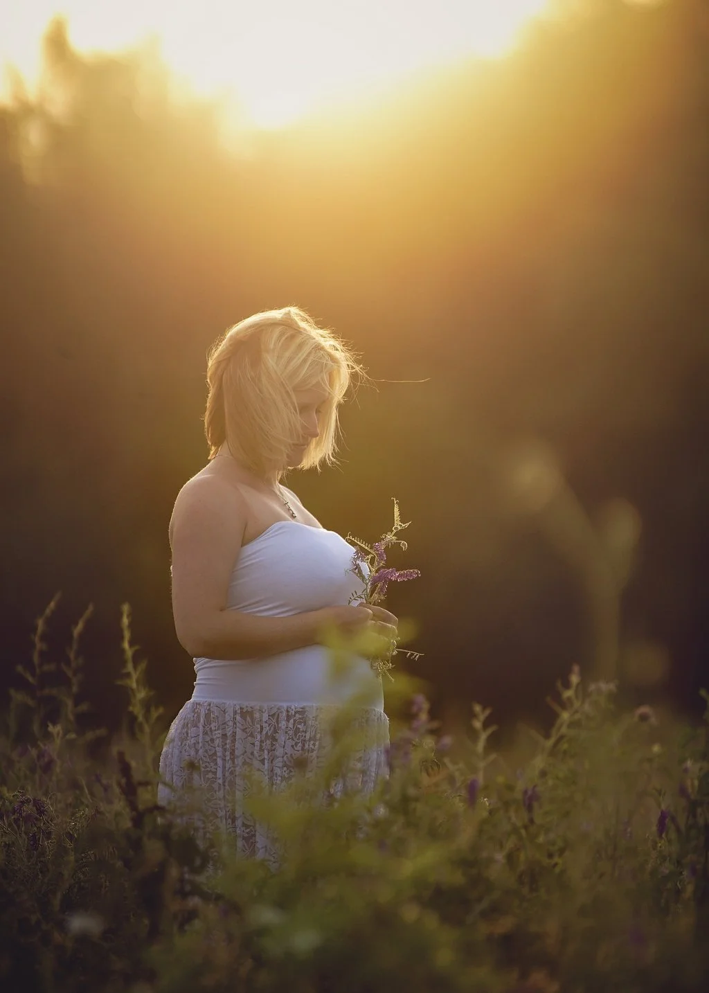 pregnant mother standing in wildflowers during maternity portrait session in South Jersey