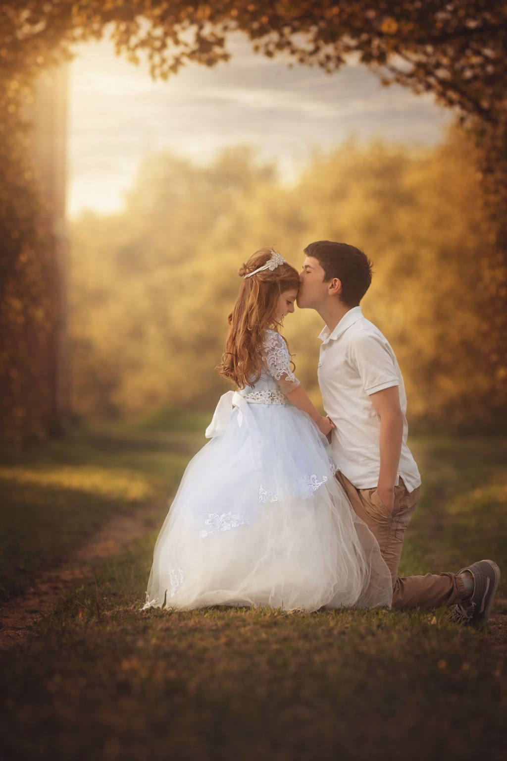 Fine art princess portrait in New Jersey showing a brother kissing his sister as she wears a crown and elegant gown