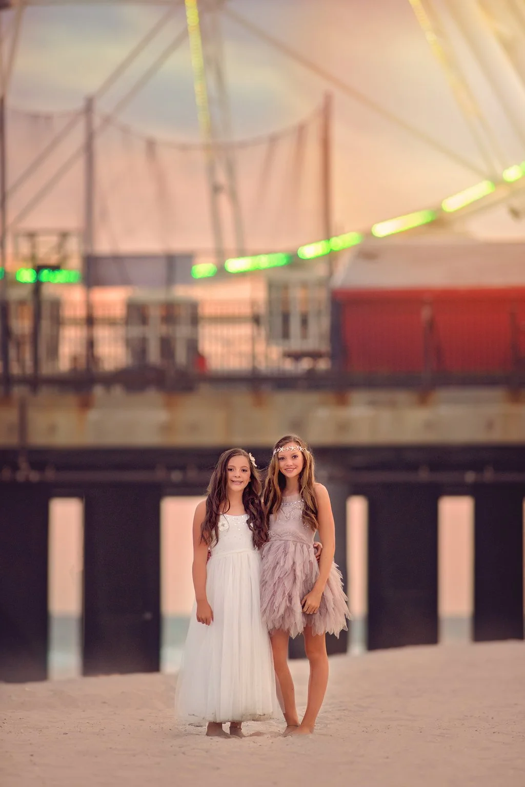 Two young girls posing in front of the pier during a South Jersey family beach photography session in Atlantic City, New Jersey