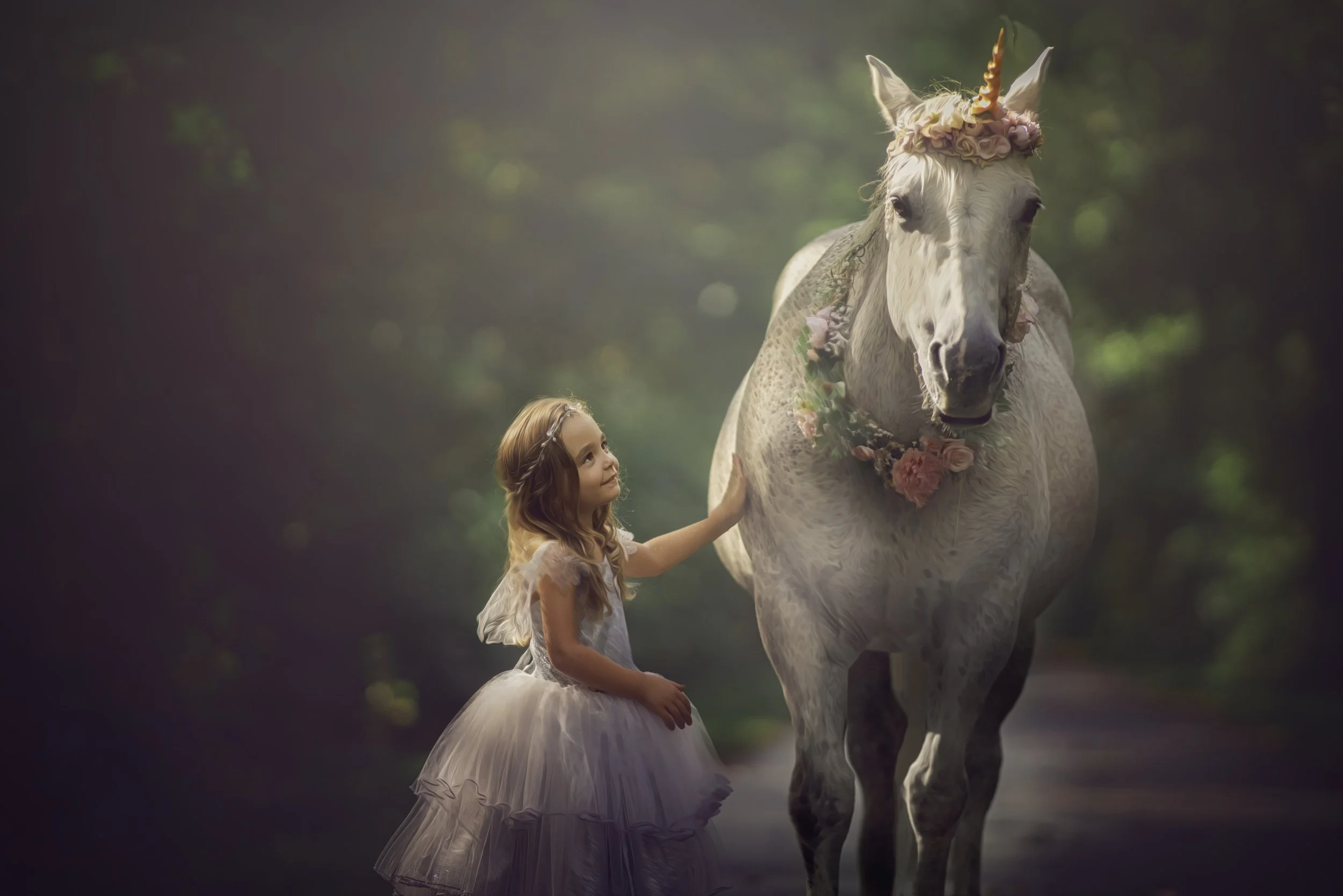 Close-up portrait of a little girl in a silver dress gently stroking a unicorn during a magical unicorn photography session in South Jersey.