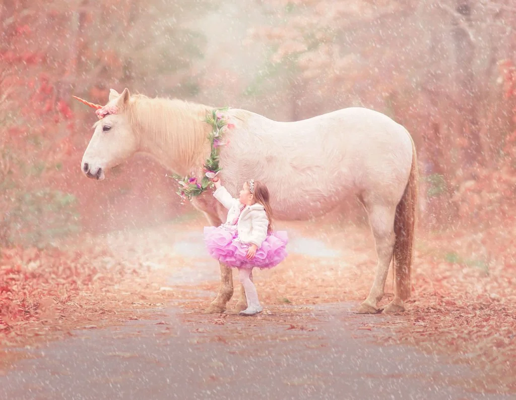 young girl holding a flower wreath on a unicorn during a magical portrait session in New Jersey