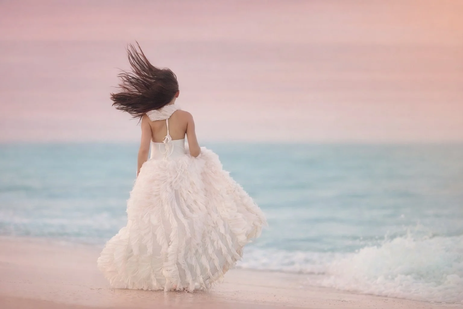 Child portrait of a young girl standing on the beach in Cape May, New Jersey, looking out at the ocean during a peaceful Jersey Shore session.