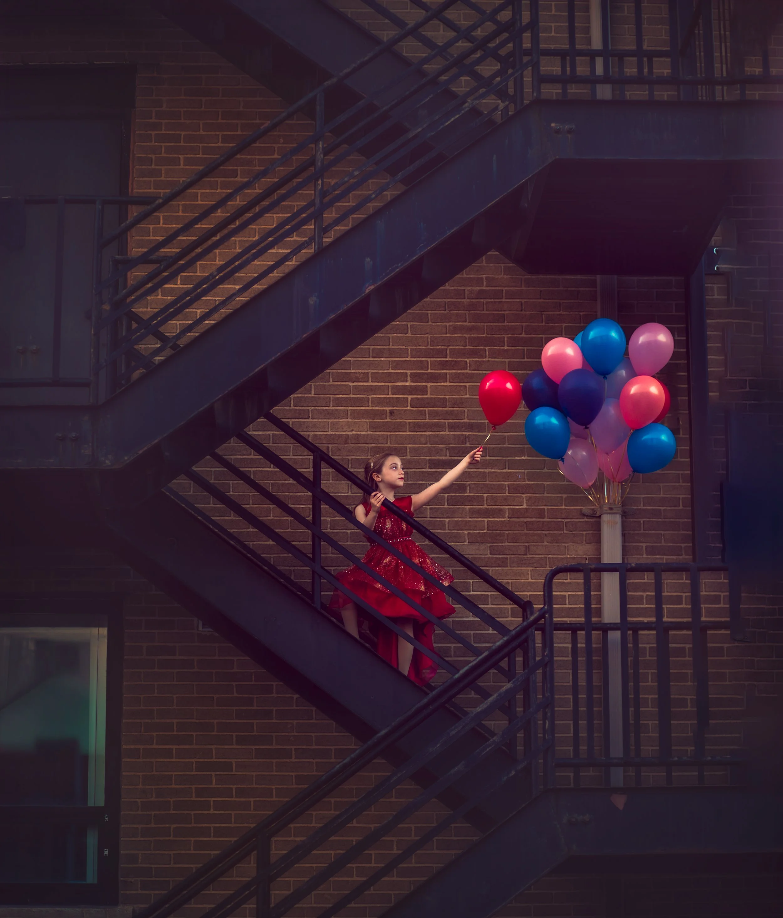 Creative child portrait in Collingswood NJ with red dress and balloons urban downtown setting