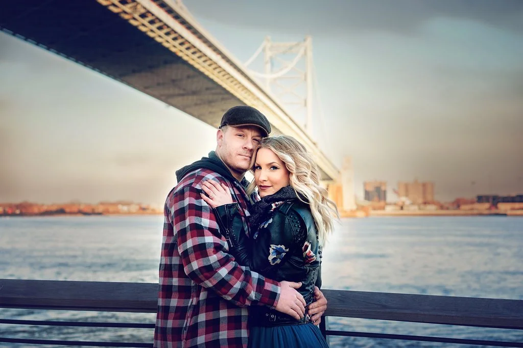 A close-up engagement portrait of an engaged couple together near the Benjamin Franklin Bridge during their session at Race Street Pier