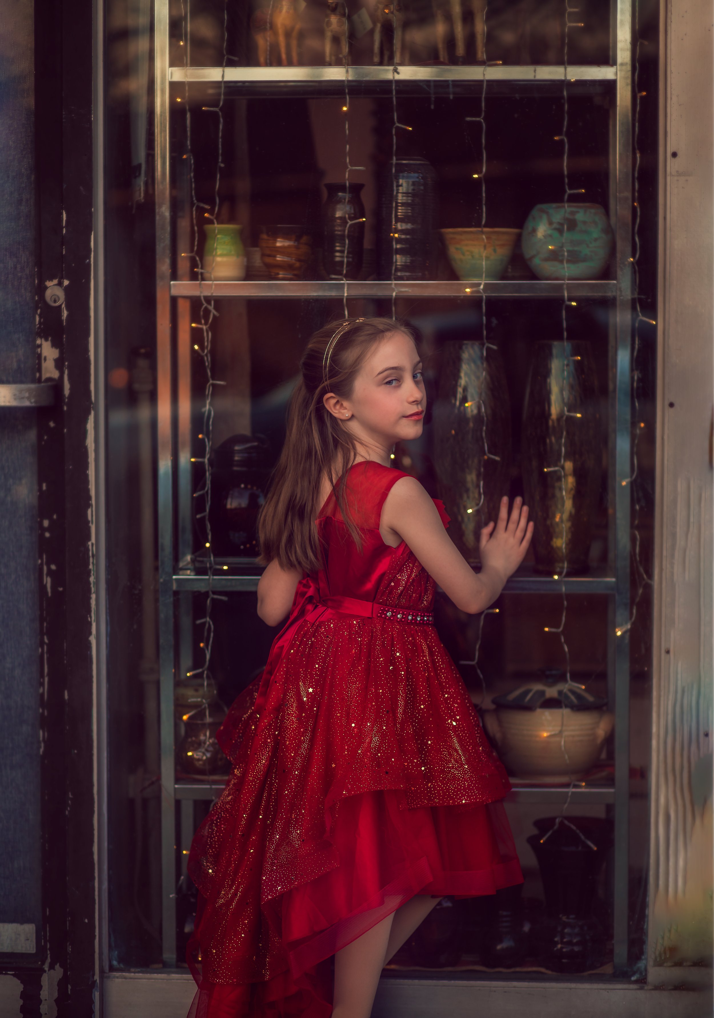 Fine art child portrait in Collingswood NJ with girl in red dress standing by window downtown