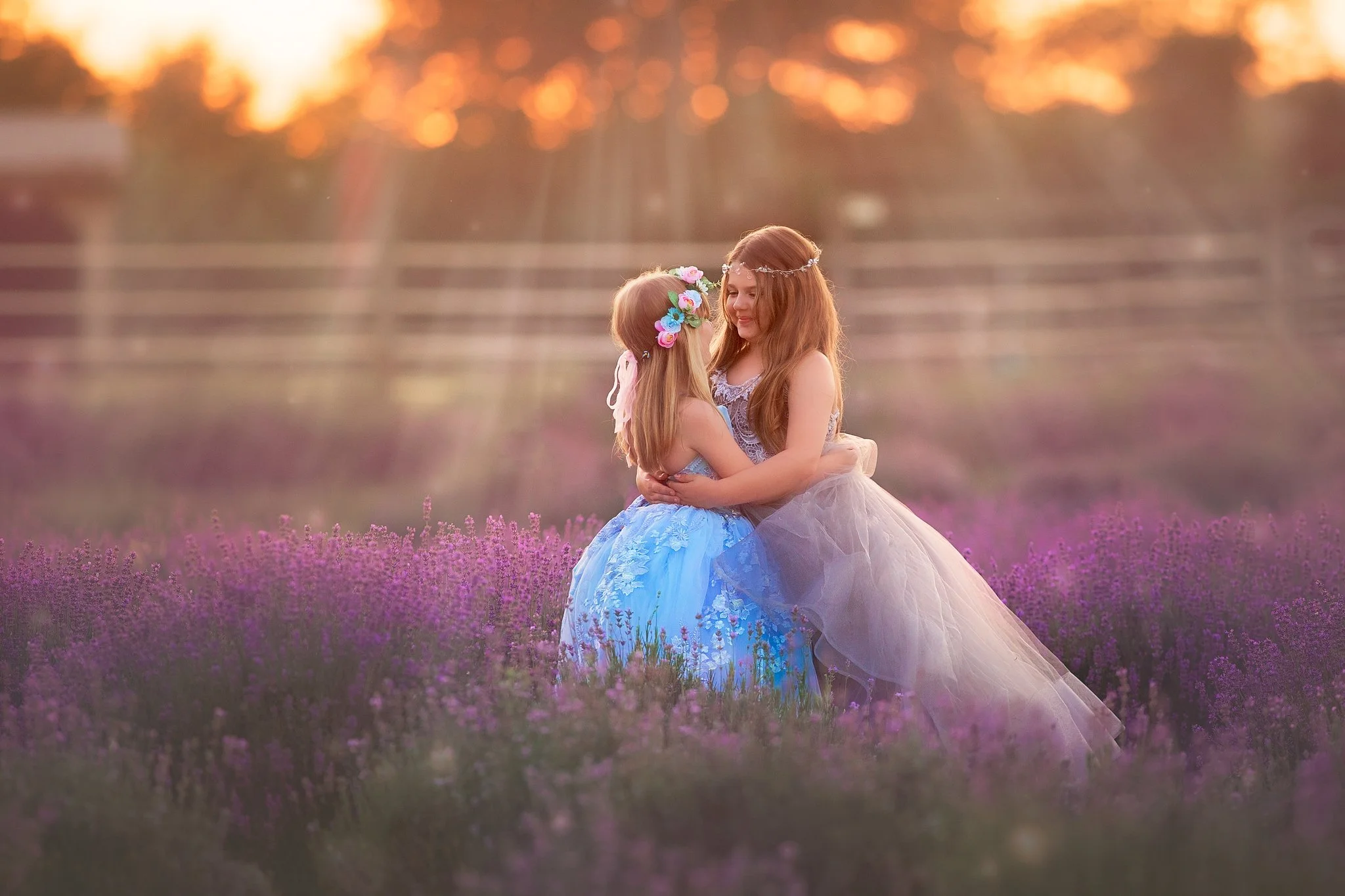 Fine art children's portrait of two sisters embracing in a lavender field, photographed by a South Jersey children and family photographer