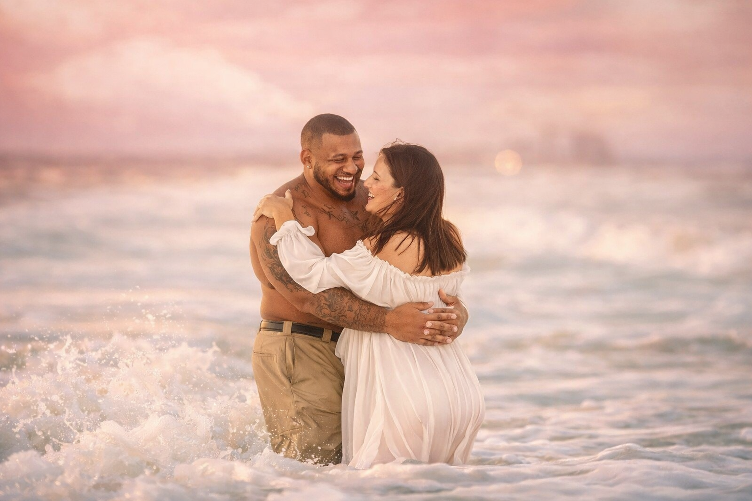 Couple laughing together in the ocean during a South Jersey maternity photography session