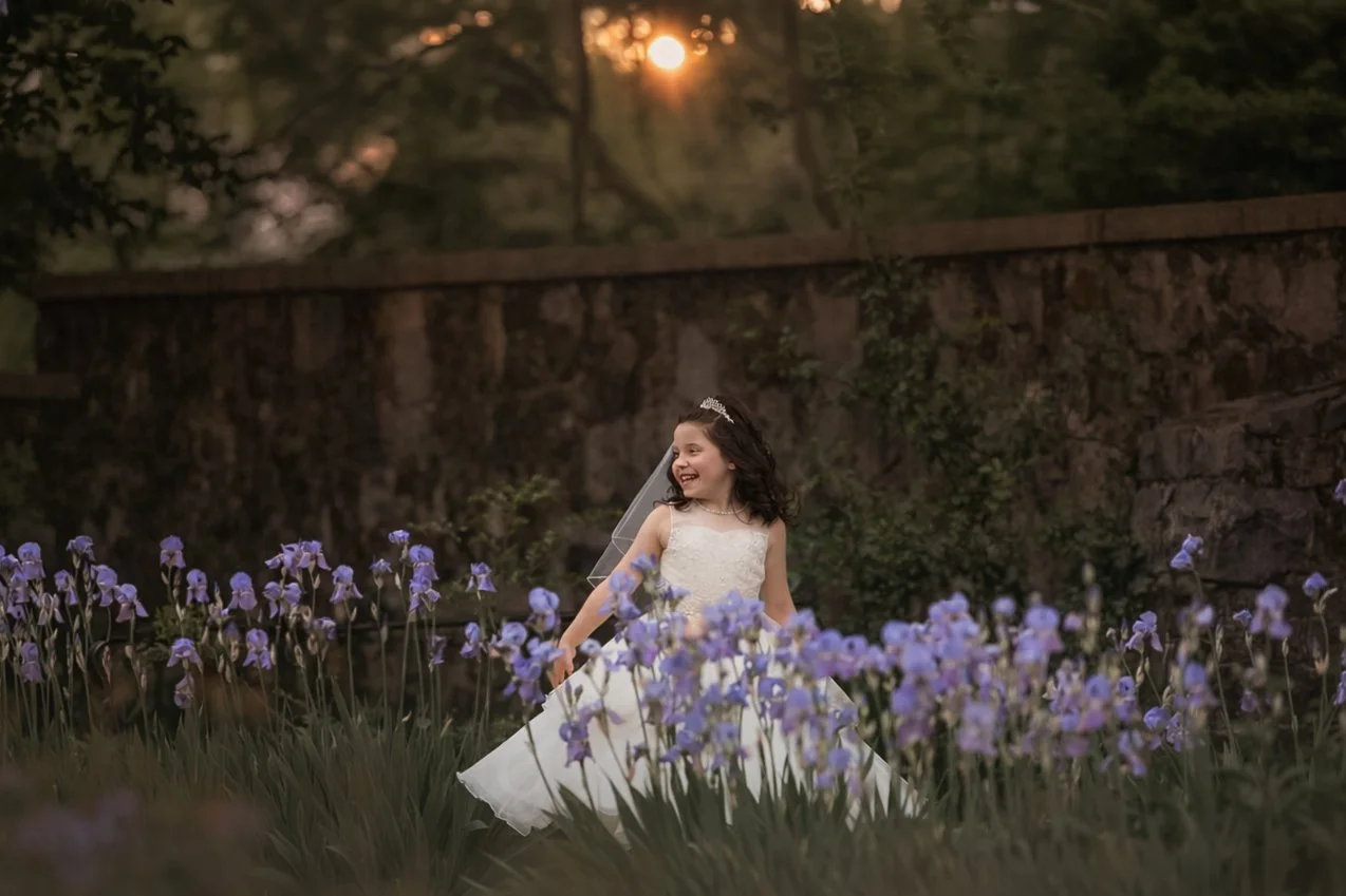 first holy communion portrait surrounded by spring flowers in New Jersey garden