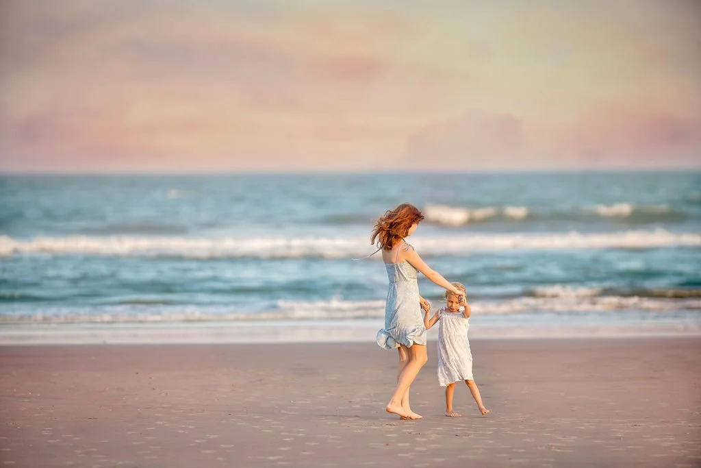 Two sisters playing ring around the rosie on the beach in Wildwood NJ during a family photo session