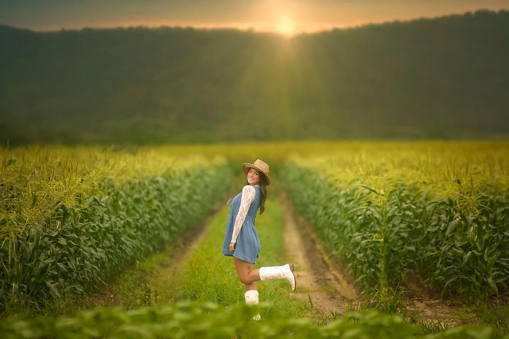 Teen girl standing in a field at sunset during a South Jersey senior portrait session with warm golden light.