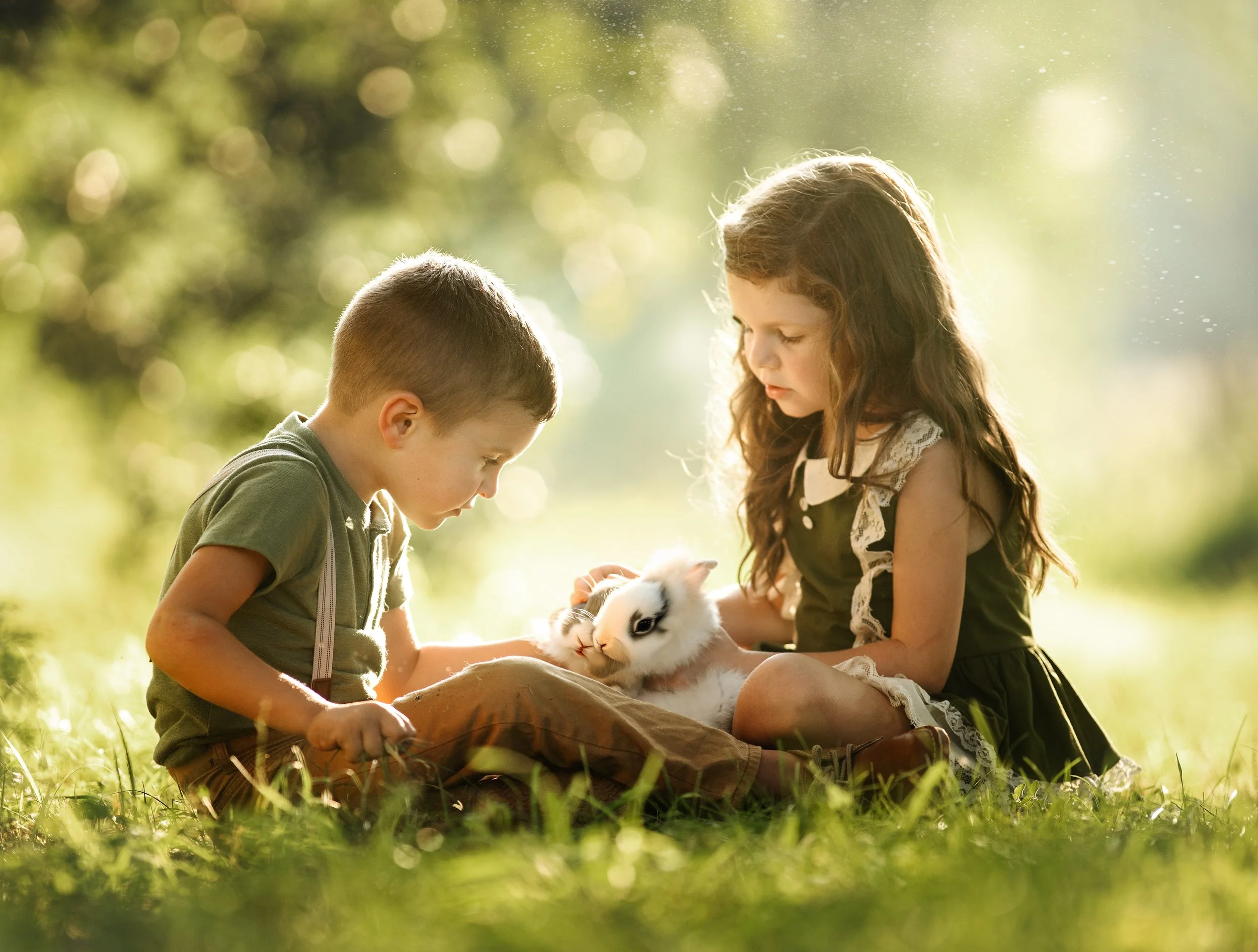 Young children sitting together with a bunny during a gentle, fine art baby and toddler portrait session in South Jersey.