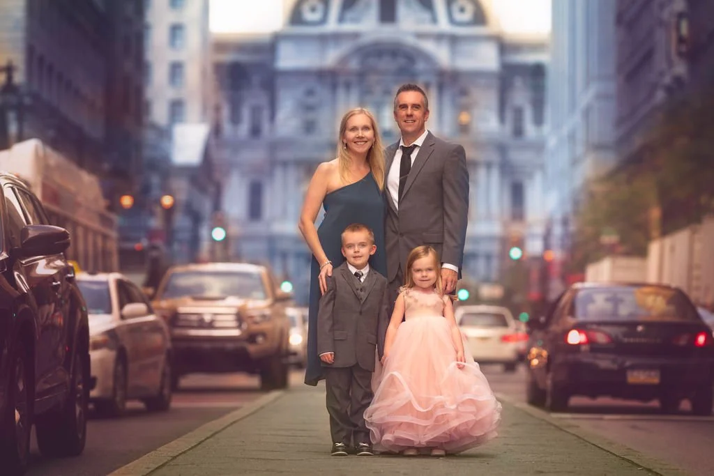 Family posing together on Broad Street in Philadelphia with City Hall in the background