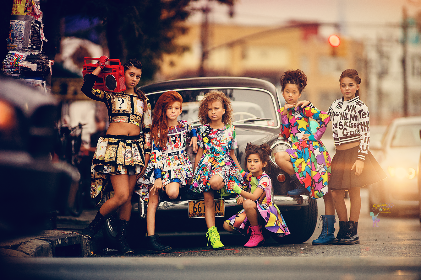 Children posing in colorful editorial outfits in an urban city setting for a fashion inspired portrait session near Philadelphia
